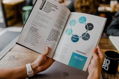 A business executive holding a book with a page displaying a changing business model.